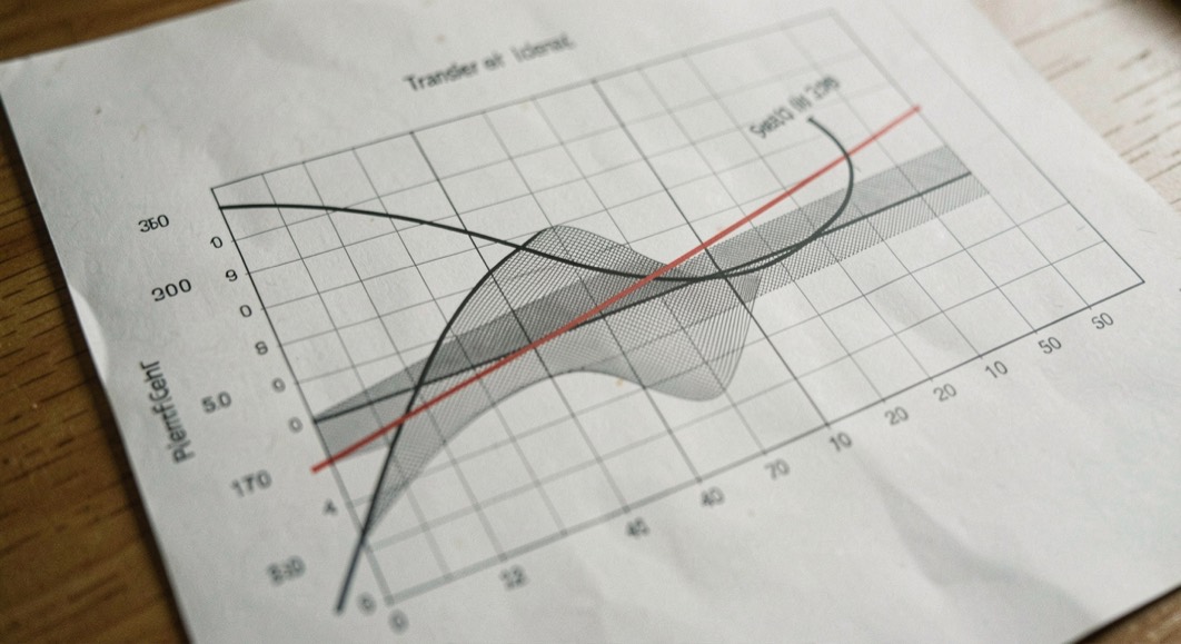 A plotted logarithmic detector transfer curve on a screen beside a detector module and a short coaxial jumper on a grey bench mat